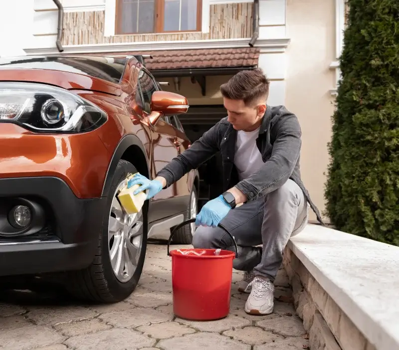 Lavage auto à domicile Villeneuve-sur-Auvers : professionnel intervenant sur un véhicule